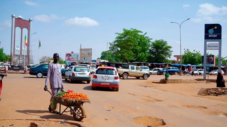 A man wheels tomatoes to sell on a bad road...