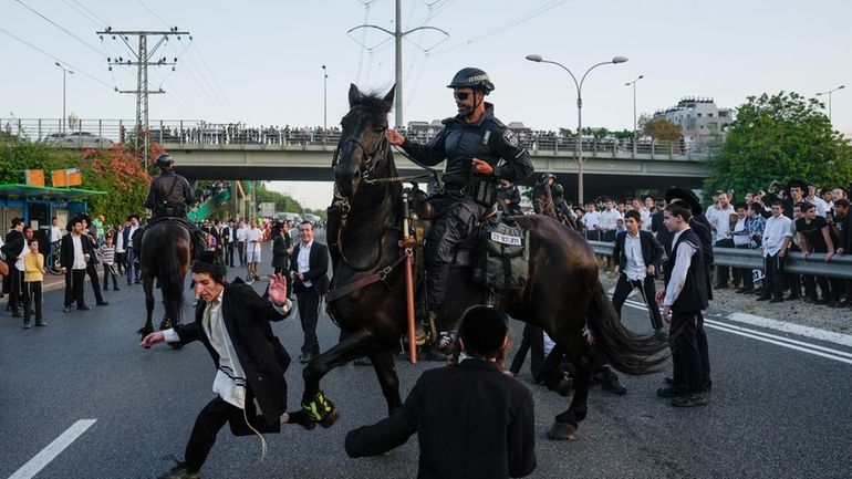 Israeli mounted police disperse Ultra-Orthodox Jews blocking a highway during...