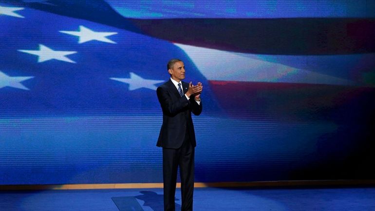 President Barack Obama stands on stage after addressing the Democratic...