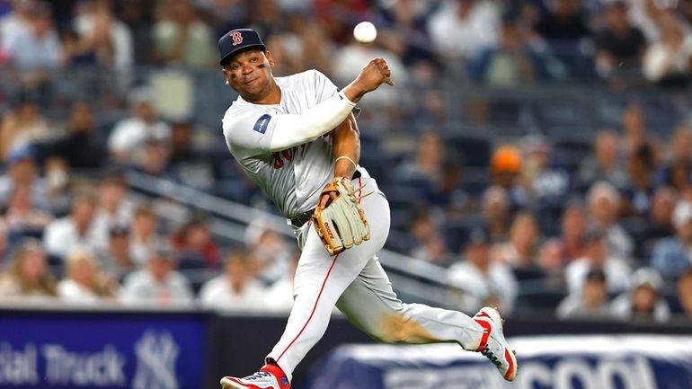 Boston Red Sox third baseman Rafael Devers throws out New...