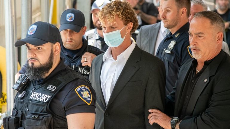 Daniel Penny, center, leaves Manhattan Criminal Court after his arraignment...