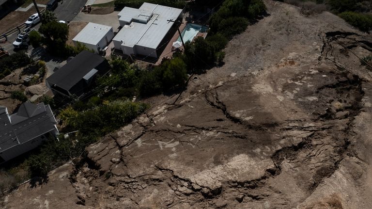 An aerial view shows a neighborhood affected by ongoing landslides...