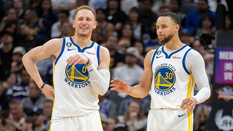 Golden State guards Donte DiVincenzo, left, and Stephen Curry enjoy a...