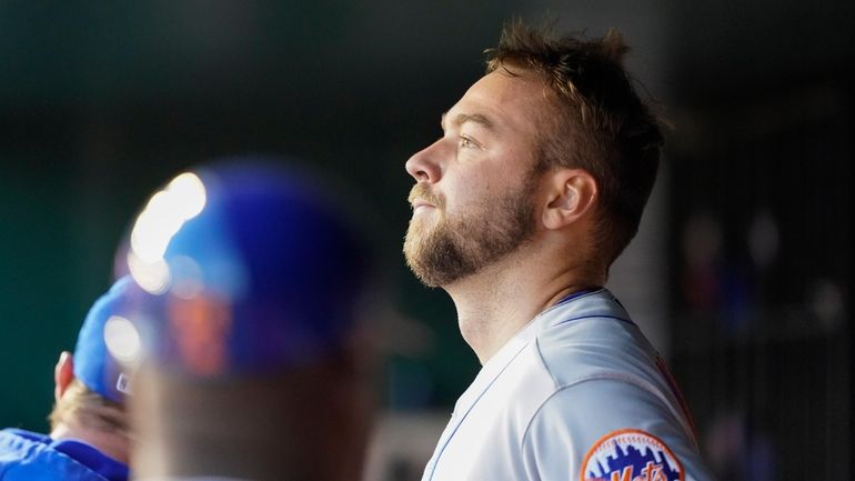 Mets starting pitcher Tylor Megill stands in the dugout after...