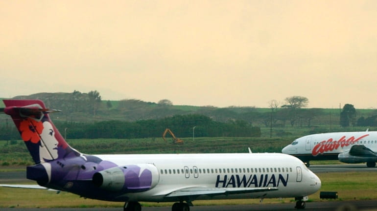An Hawaiian Airlines plane taxis for position at Kahalui, Hawaii,...
