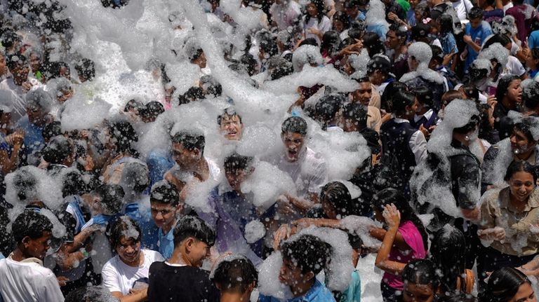 Youths are showered with foam during a march against U.S....