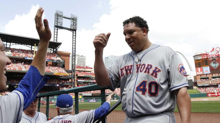 Mets pitcher Bartolo Colon is congratulated by teammates as he...