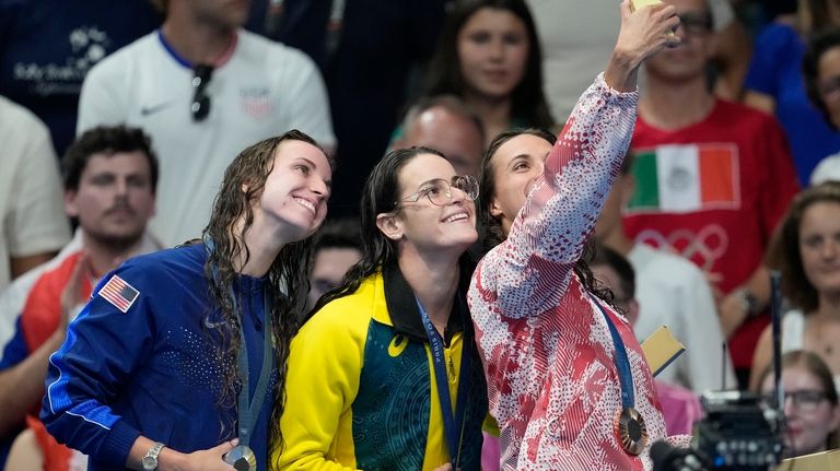 Gold medalist Kaylee McKeown, centre, of Australia, stands with silver...