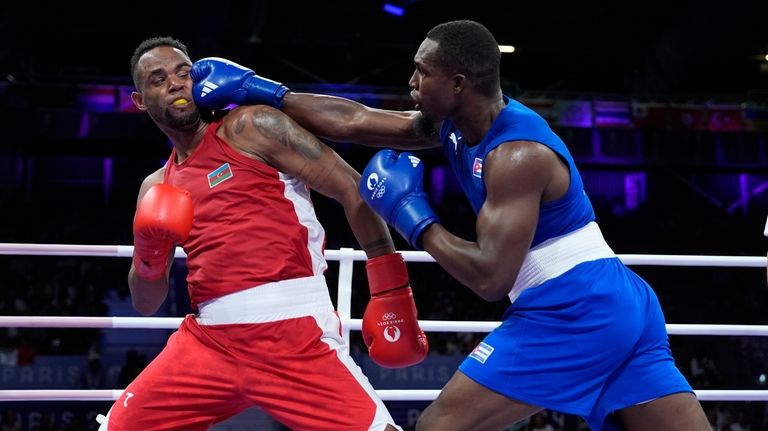 Cuba's Julio La Cruz Peraza, right, punches Azerbaijan's Loren Alfonso,...