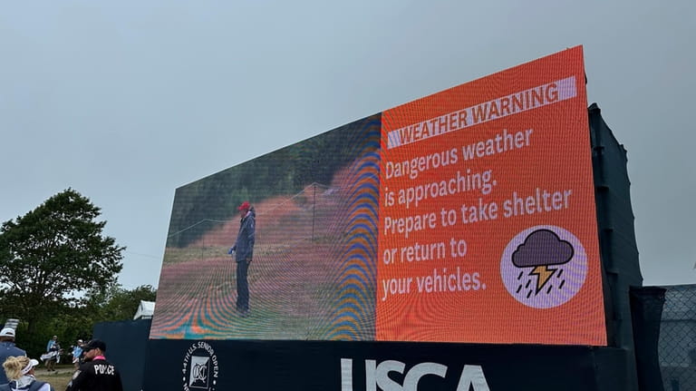 A sign warns fans to take shelter as severe weather...