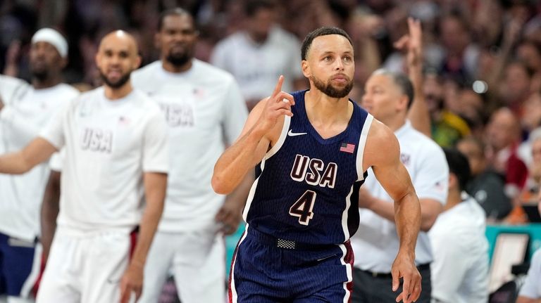 Stephen Curry, of the United States, celebrates after hitting a...