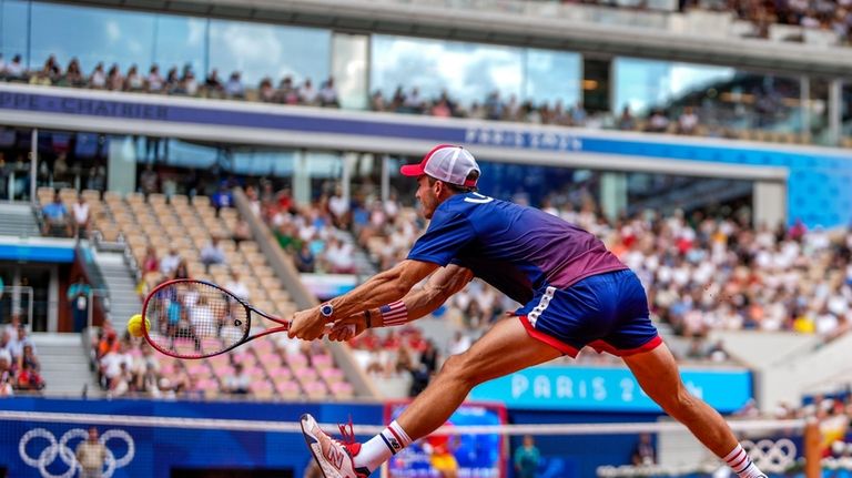 Tommy Paul, of United States returns the ball against Carlos...