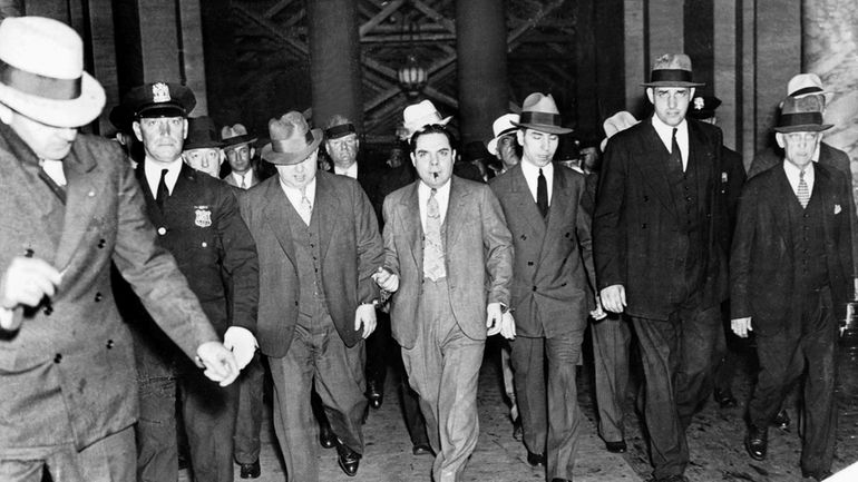  Lucky Luciano (with handcuffs and cigarette) leaves a New York...