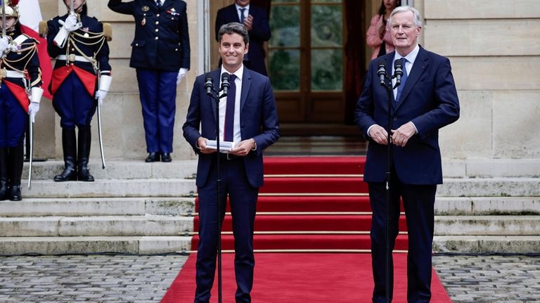 New French prime minister Michel Barnier, right, and outgoing prime...