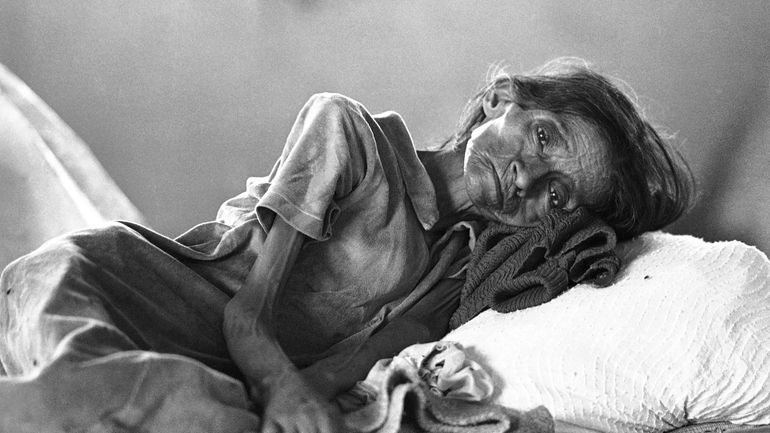 A Guatemalan woman, showing signs of severe malnutrition, lies on...