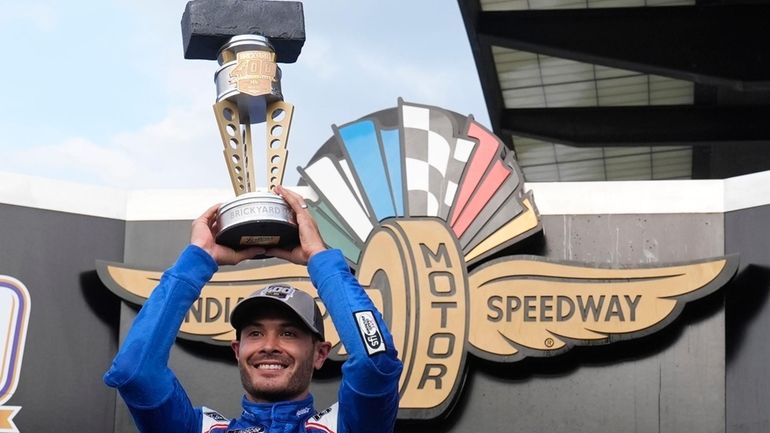 Kyle Larson holds the trophy after winning a NASCAR Cup...