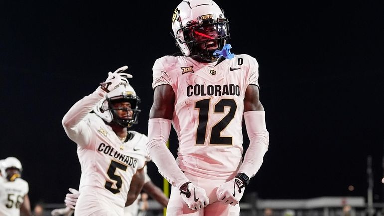 Colorado wide receiver Travis Hunter, right, celebrates after catching a...