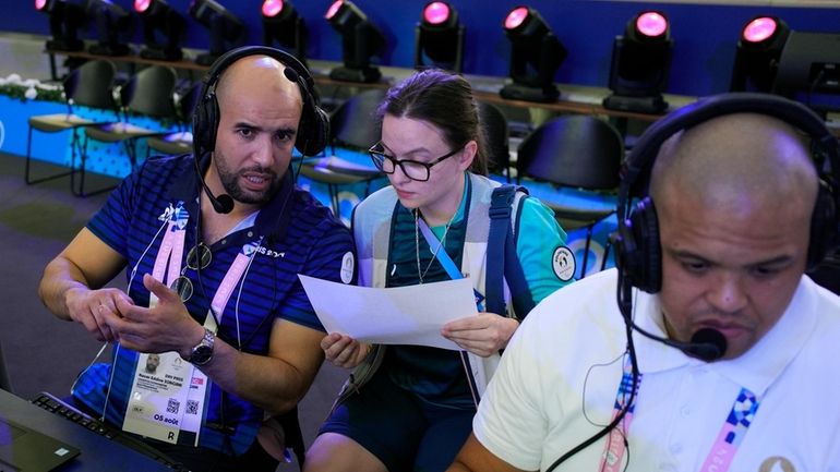 Laureline Jeunemaitre, 24, right, assists Nacer Eddine Zorgani as he...