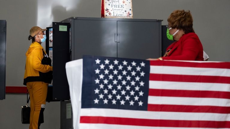 A voter marks her ballot during the first day of...