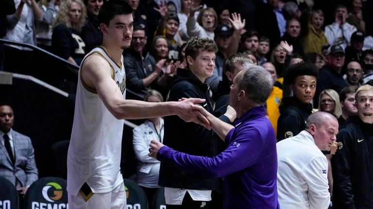 Northwestern Wildcats head coach Chris Collins shakes hands with Purdue...