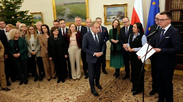 Poland's new Prime Minister Donald Tusk, center, receives written confirmation...