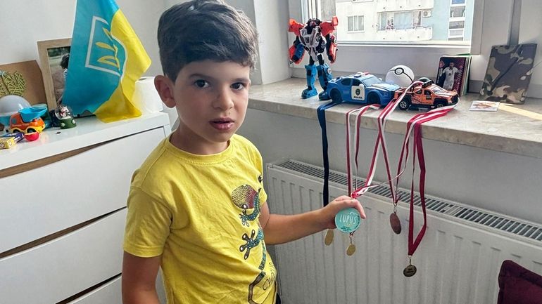 Sava Trypolsky, a 7-year-old boy from Ukraine, shows off soccer...