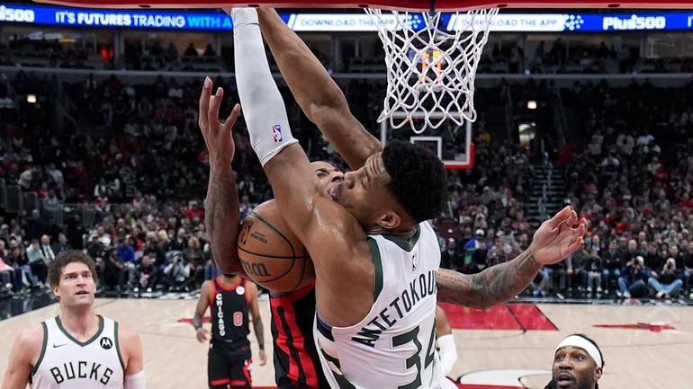 Chicago Bulls' DeMar DeRozan collides with Milwaukee Bucks' Giannis Antetokounmpo...