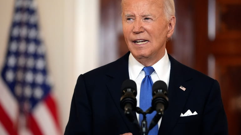 President Joe Biden speaks in the Cross Hall of the...