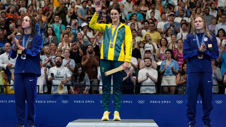 Gold medalist Australia's Kaylee McKeown, centre, stands with silver medalist,...