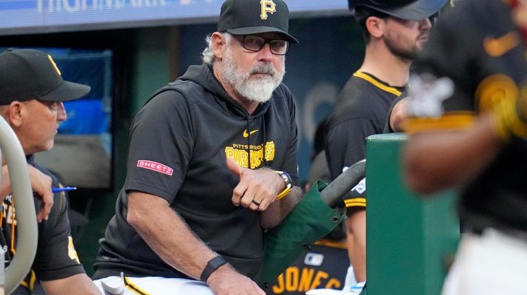 Pittsburgh Pirates manager Derek Shelton, center, stands on the dugout...