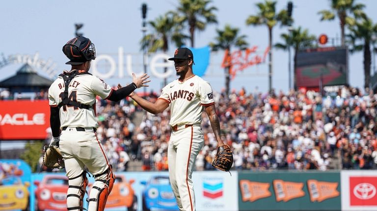 San Francisco Giants pitcher Camilo Doval, right, celebrates with catcher...