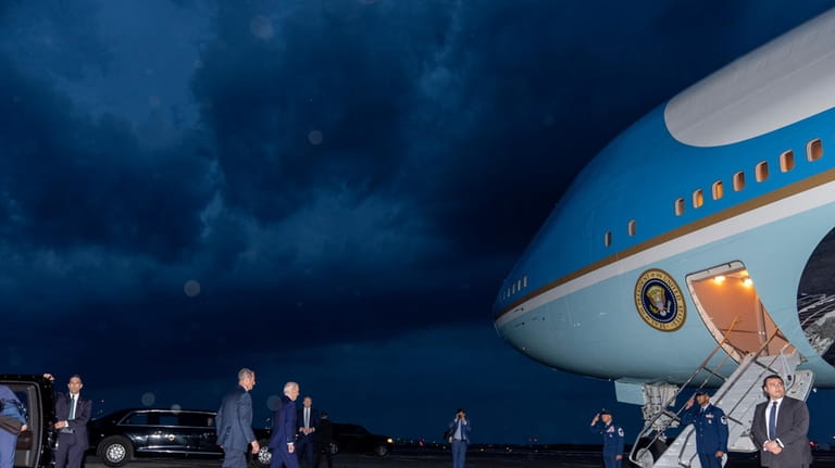 President Joe Biden walks to board Air Force One as...