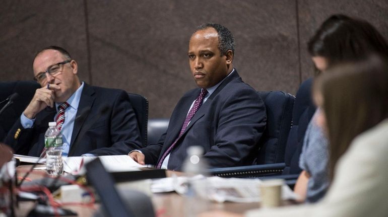 Suffolk Legislature's Presiding Officer Duwayne Gregory listens to testimony from...