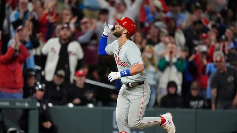Philadelphia Philliesd' Bryce Harper gestures as he runs the bases...