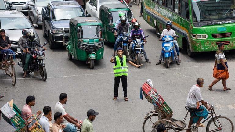 A student directs traffic in Dhaka, Bangladesh, on Aug. 8,...