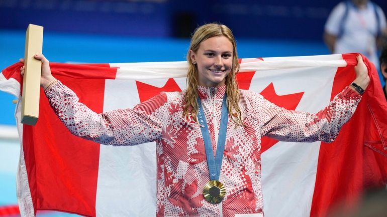 Summer McIntosh, of Canada, celebrates with the gold medal during...