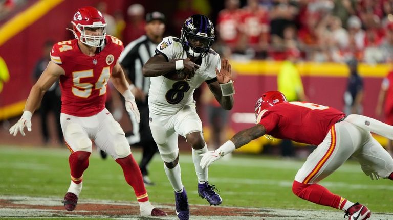 Baltimore Ravens quarterback Lamar Jackson (8) runs with the ball...