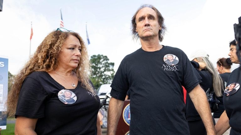 Terry and Santo Puzio, parents of Nick Puzio, stand outside...