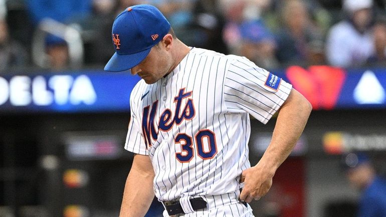 Mets relief pitcher David Robertson walks to the dugout after...