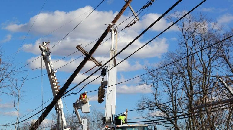 LIPA crews work on a pole leaning over the westbound...