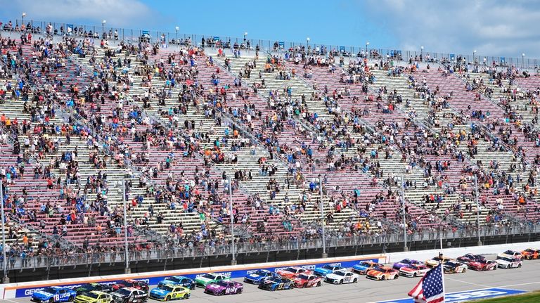 Racing fans watch a NASCAR Cup Series auto race at...