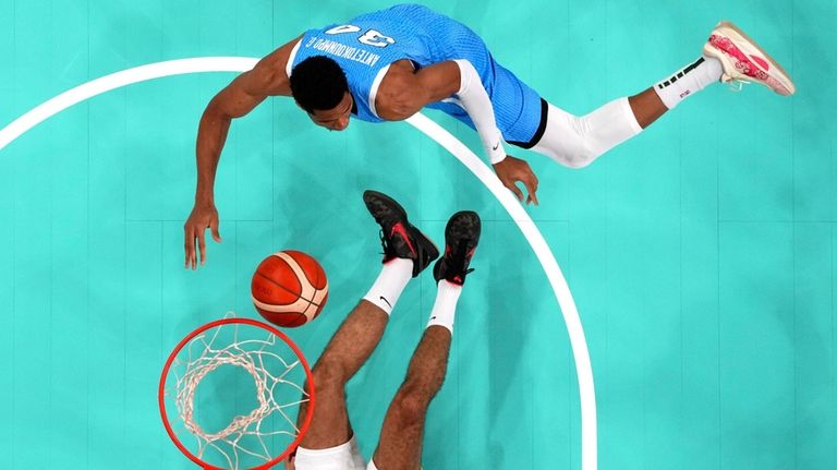 Giannis Antetokounmpo, top, of Greece, shoots as Santi Aldama, of...