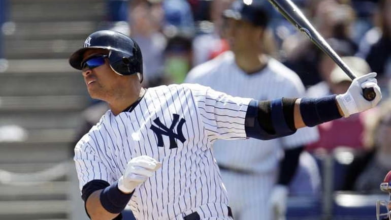New York Yankees' Alex Rodriguez follows through on a home...