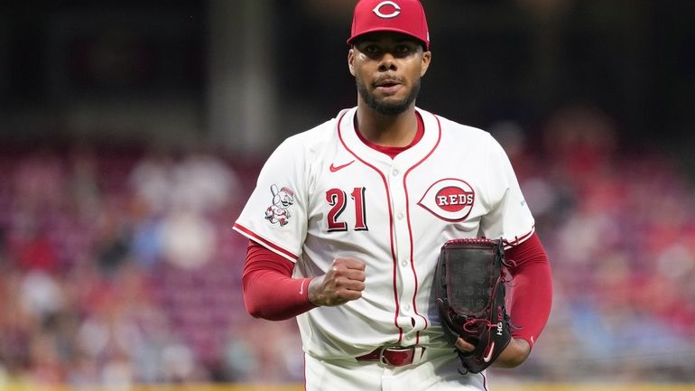 Cincinnati Reds' Hunter Greene pumps his fist after walking off...