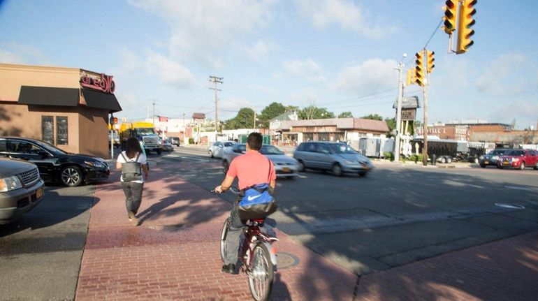 Cars, pedestrians, and cyclists navigate the intersection of Front Street...