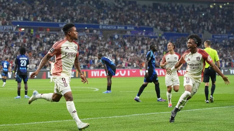 Lyon's Gift Orban, left, celebrates with Lyon's Malick Fofana after...