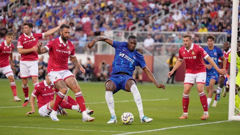 Chelsea defender Tosin Adarabioyo, center, moves the ball past Wrexham...