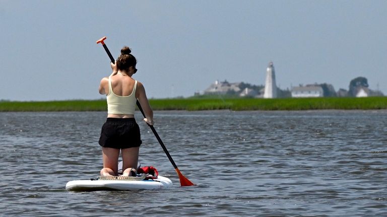 A padder boarder heads to Great Island in Old Lyme,...