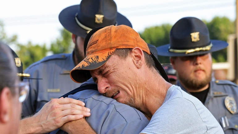 Bo Lanthrop, right, embraces a member of the Fordyce Police...