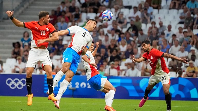 Paraguay's Gilberto Flores (5) is unable to deflect a cross...